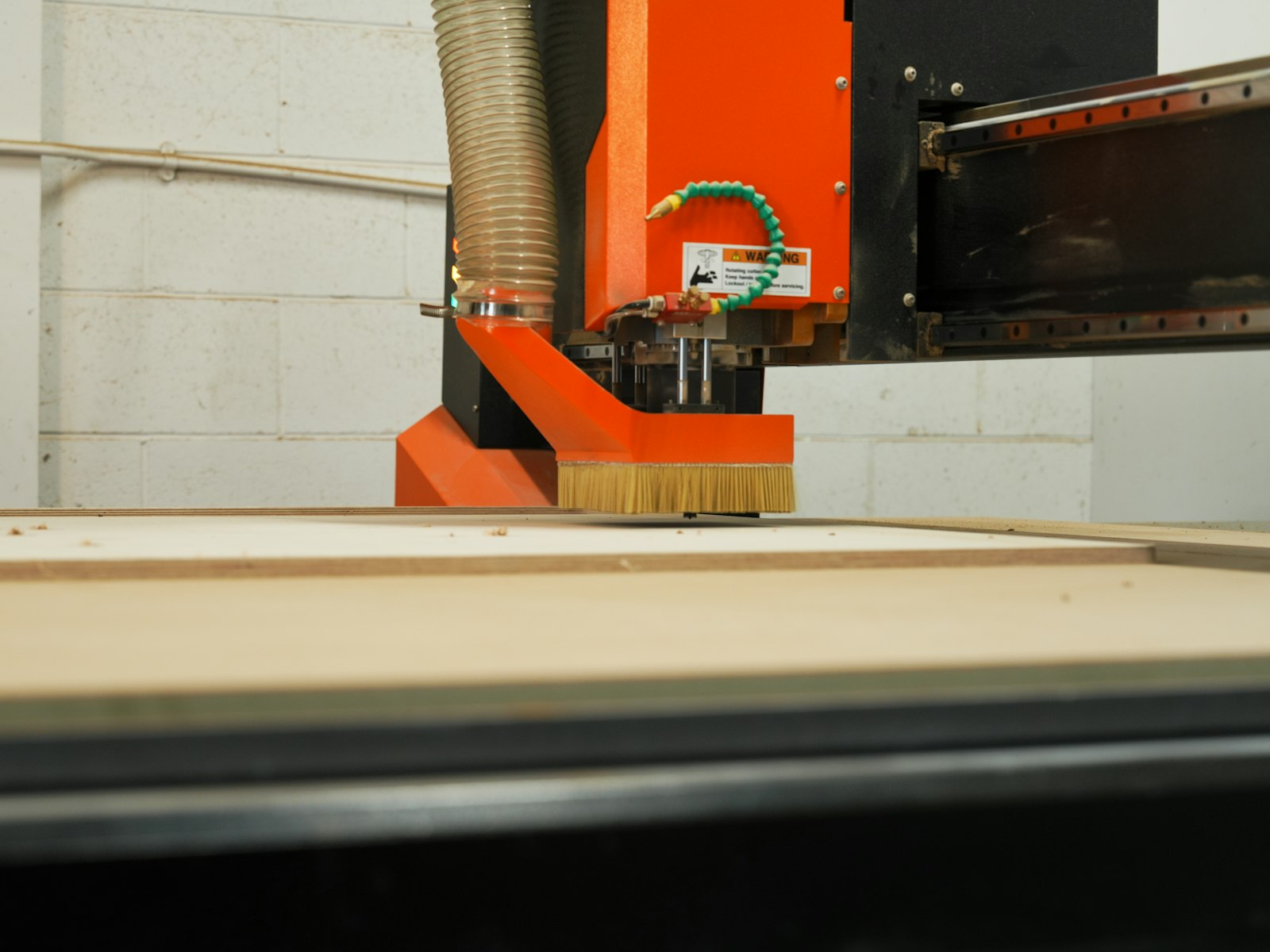 An NC boring machine drilling a run of shelf pin holes into a panel.