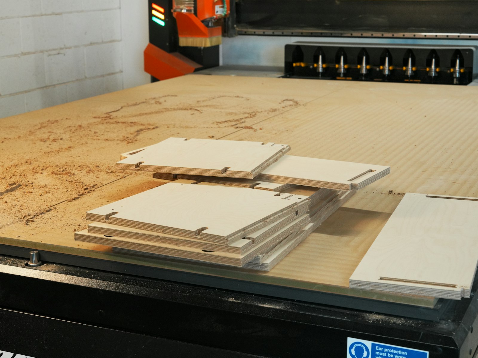 The factory floor with stacked panel stock and cutting machinery.